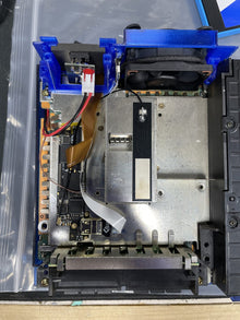 Game console opened up, exposing the disc drive and metal shielding