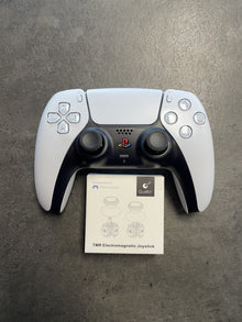 White PlayStation 5 DualSense controller beside a small replacement part