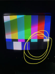 CRT screen showing color bars in a darkened room
