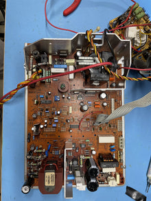 Solder side of an arcade monitor chassis on the bench, wiring loom still attached
