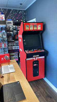 Neo Geo arcade cabinet in the shop beside a laptop