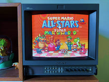 Sony PVM Trinitron broadcast monitor on a shelf, displaying a bright game title screen