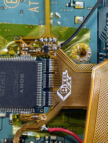 Sony chip and ribbon cable on a board under magnification