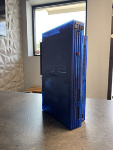 PlayStation 2 in a translucent blue shell, standing upright